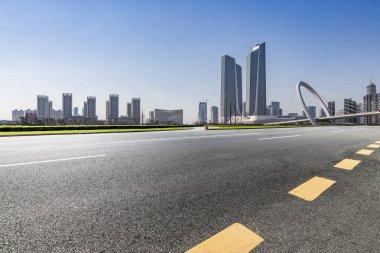 Panoramik siluet ve boş yolu, boş beton zemini olan modern iş binaları.