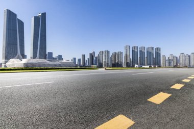 Panoramik siluet ve boş yolu, boş beton zemini olan modern iş binaları.