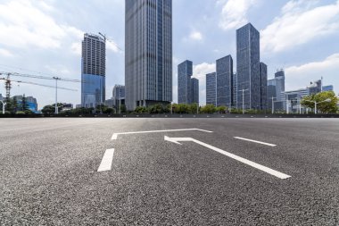 Panoramik siluet ve boş yolu, boş beton zemini olan modern iş binaları.