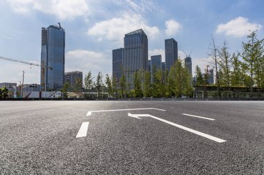 Panoramik siluet ve boş yolu, boş beton zemini olan modern iş binaları.