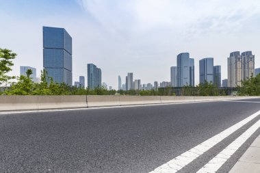 Panoramik siluet ve boş yolu, boş beton zemini olan modern iş binaları.