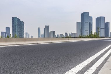 Panoramik siluet ve boş yolu, boş beton zemini olan modern iş binaları.