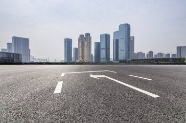 Panoramik siluet ve boş yolu, boş beton zemini olan modern iş binaları.