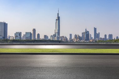 Panoramik siluet ve boş yolu, boş beton zemini olan modern iş binaları.
