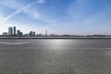 Panoramik siluet ve boş yolu, boş beton zemini olan modern iş binaları.