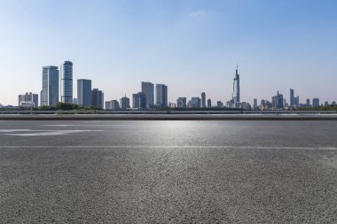 Panoramik siluet ve boş yolu, boş beton zemini olan modern iş binaları.