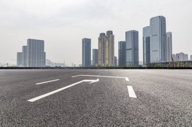 Panoramik siluet ve boş yolu, boş beton zemini olan modern iş binaları.