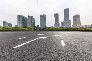 Panoramik siluet ve boş yolu, boş beton zemini olan modern iş binaları.