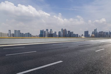 Panoramik siluet ve boş yolu, boş beton zemini olan modern iş binaları.