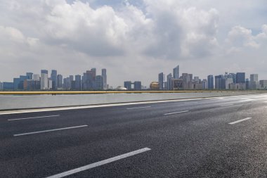 Panoramik siluet ve boş yolu, boş beton zemini olan modern iş binaları.
