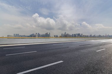 Panoramik siluet ve boş yolu, boş beton zemini olan modern iş binaları.