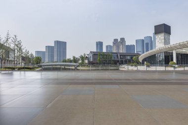 Panoramik siluet ve boş yolu, boş beton zemini olan modern iş binaları.