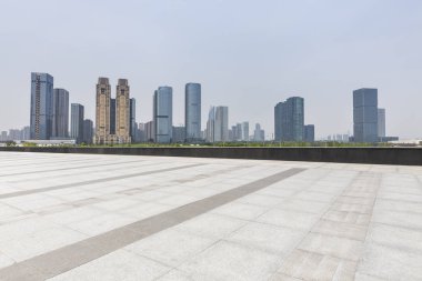 Panoramik siluet ve boş yolu, boş beton zemini olan modern iş binaları.