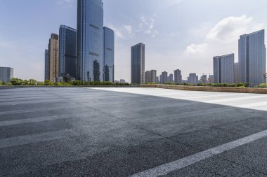 Panoramik siluet ve boş yolu, boş beton zemini olan modern iş binaları.