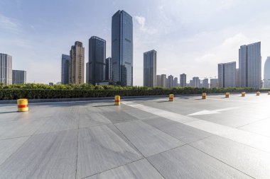 Panoramik siluet ve boş yolu, boş beton zemini olan modern iş binaları.