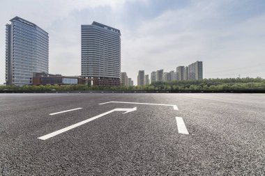 Panoramik siluet ve boş yolu, boş beton zemini olan modern iş binaları.
