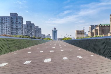 Panoramik siluet ve boş yolu, boş beton zemini olan modern iş binaları.