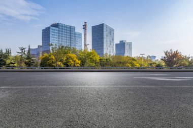 Panoramik siluet ve boş yolu, boş beton zemini olan modern iş binaları.