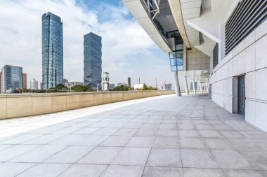 Panoramik siluet ve boş yolu, boş beton zemini olan modern iş binaları.