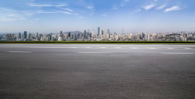 Panoramik siluet ve boş yolu, boş beton zemini olan modern iş binaları.
