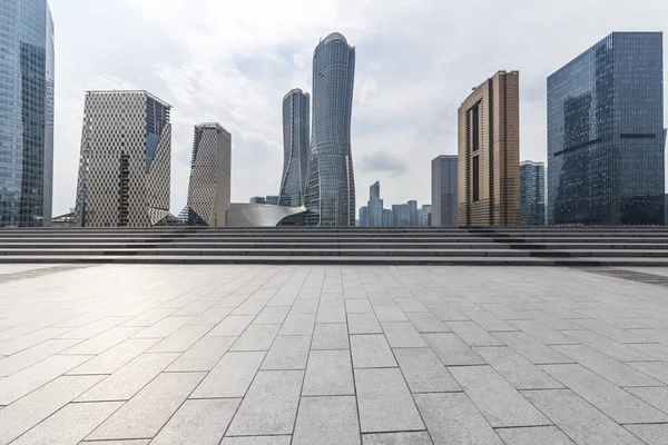 Panoramik siluet ve boş yolu, boş beton zemini olan modern iş binaları.