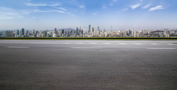 Panoramik siluet ve boş yolu, boş beton zemini olan modern iş binaları.