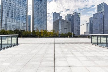 Panoramik siluet ve boş yolu, boş beton zemini olan modern iş binaları.