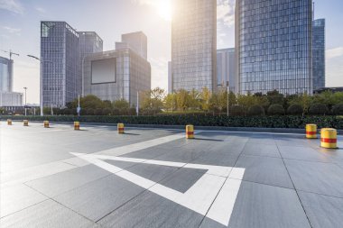 Panoramik siluet ve boş yolu, boş beton zemini olan modern iş binaları.
