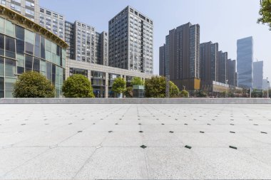 Panoramik siluet ve boş yolu, boş beton zemini olan modern iş binaları.