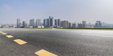 Panoramik siluet ve boş yolu, boş beton zemini olan modern iş binaları.