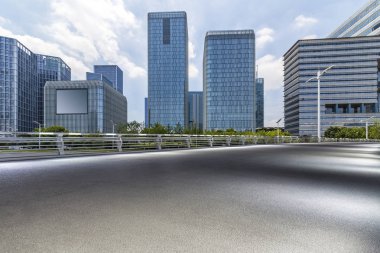 Panoramik siluet ve boş yolu, boş beton zemini olan modern iş binaları.