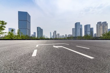 Panoramik siluet ve boş yolu, boş beton zemini olan modern iş binaları.