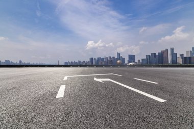 Panoramik siluet ve boş yolu, boş beton zemini olan modern iş binaları.