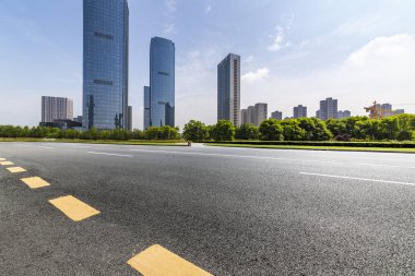 Panoramik siluet ve boş yolu, boş beton zemini olan modern iş binaları.