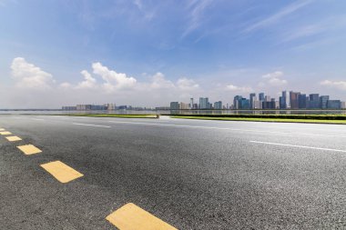 Panoramik siluet ve boş yolu, boş beton zemini olan modern iş binaları.