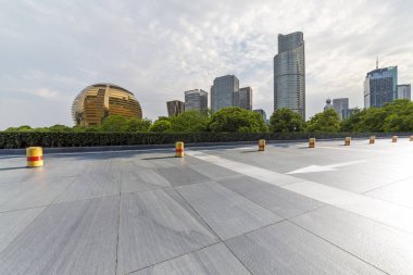 Panoramik siluet ve boş yolu, boş beton zemini olan modern iş binaları.