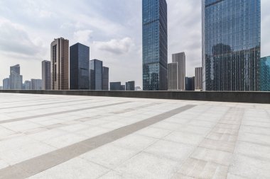 Panoramik siluet ve boş yolu, boş beton zemini olan modern iş binaları.