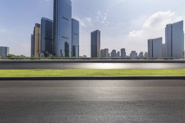 Panoramik siluet ve boş yolu, boş beton zemini olan modern iş binaları.