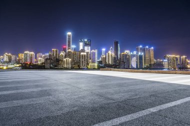 Panoramik siluet ve boş yolu, boş beton zemini olan modern iş binaları.