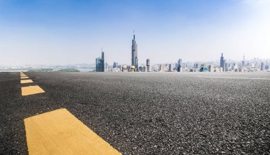 Panoramik siluet ve boş yolu, boş beton zemini olan modern iş binaları.