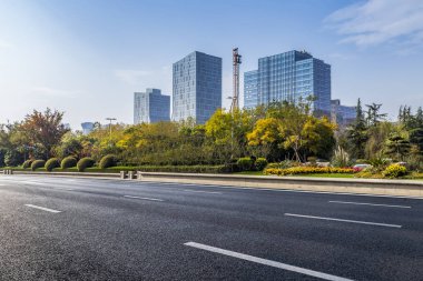 Panoramik siluet ve boş yolu, boş beton zemini olan modern iş binaları.