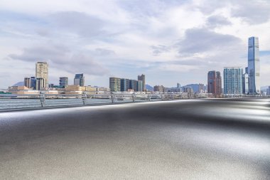 Panoramik siluet ve boş yolu, boş beton zemini olan modern iş binaları.