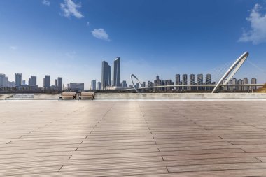 Panoramik siluet ve boş yolu, boş beton zemini olan modern iş binaları.