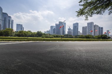 Panoramik siluet ve boş yolu, boş beton zemini olan modern iş binaları.