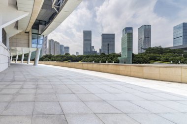 Panoramik siluet ve boş yolu, boş beton zemini olan modern iş binaları.