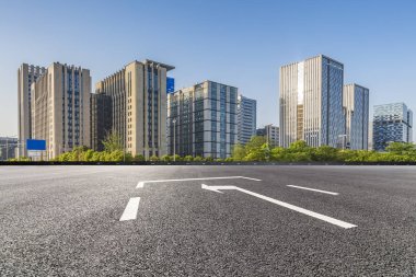 Panoramik siluet ve boş yolu, boş beton zemini olan modern iş binaları.
