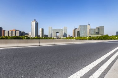 Panoramik siluet ve boş yolu, boş beton zemini olan modern iş binaları.