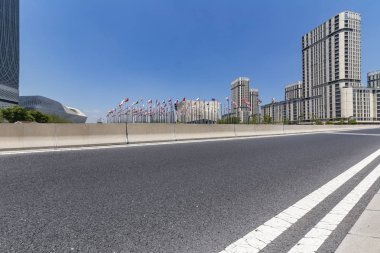 Panoramik siluet ve boş yolu, boş beton zemini olan modern iş binaları.