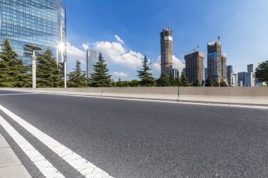 Panoramik siluet ve boş yolu, boş beton zemini olan modern iş binaları.