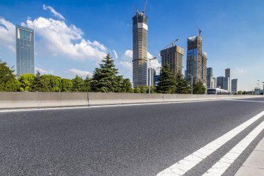 Panoramik siluet ve boş yolu, boş beton zemini olan modern iş binaları.